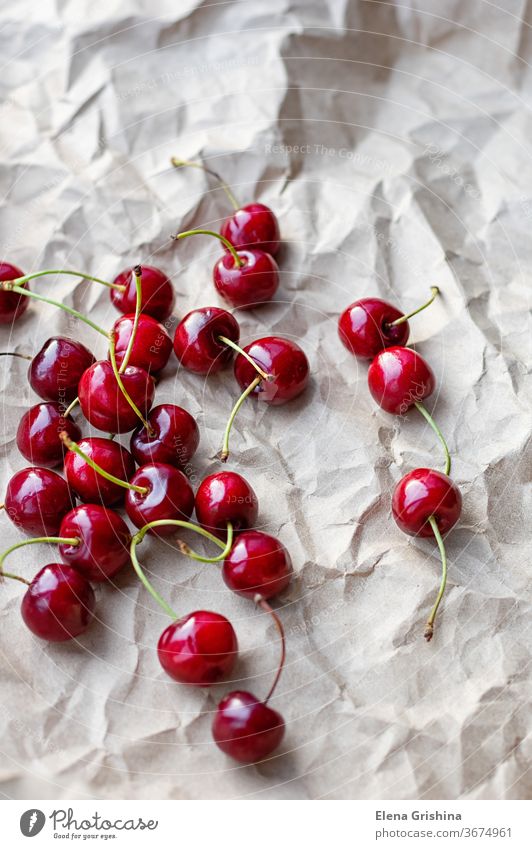 Beeren von reifen Kirschen auf einem Hintergrund aus Bastelpapier Süßkirsche rot Handwerk Papier frisch organisch Dessert süß Gesundheit Diät Sommer Frucht