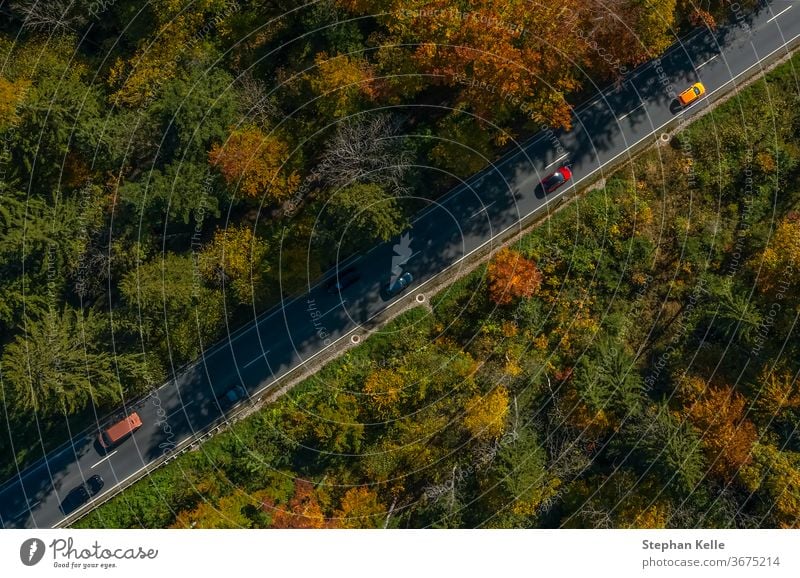 Vertikale Ansicht aus einer Drohne an einer Herbststraße. PKW Geschwindigkeit Dröhnen fallen diagonal inspirierend Straße Sonne Natur Landschaft fantastisch