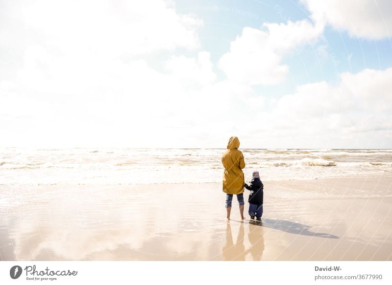 Mutter und Kind am Strand alleinerziehend zusammen zusammenhalt Mutter mit Kind gemeinsam Urlaub Eltern Familie Sonnenlicht Rückansicht zwei personen