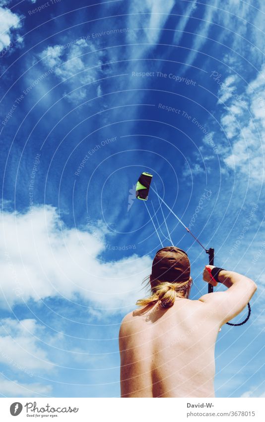 Mann lässt bei Bombenwetter einen Drachen steigen steigen lassen drachensteigen junger Mann Froschperspektive blau Himmel Wolken Sommer hobby Wind Spielen Luft