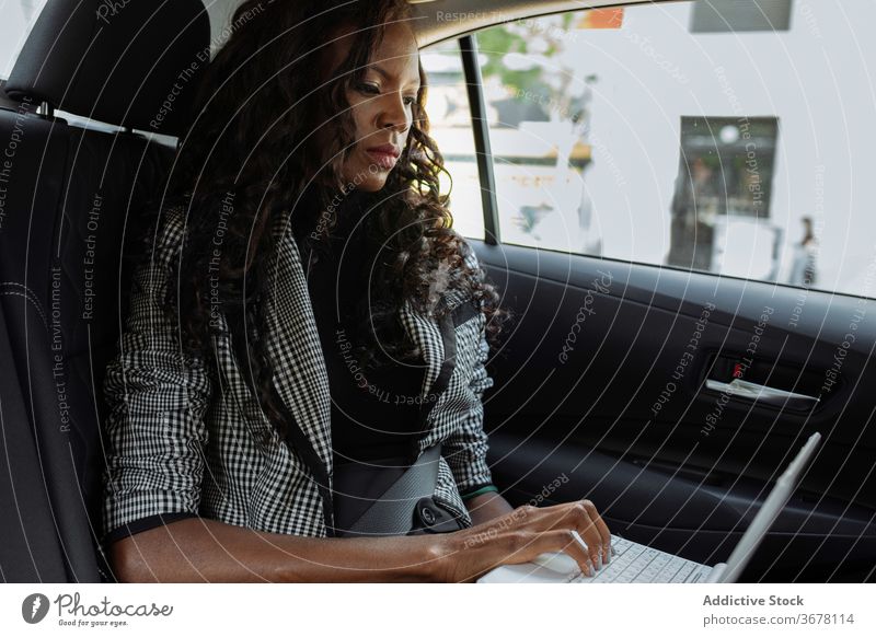 Geschäftsfrau mit Laptop im Auto PKW benutzend Arbeit Frau beschäftigt modern ernst Apparatur jung Afroamerikaner schwarz ethnisch Ausflug urban Gerät