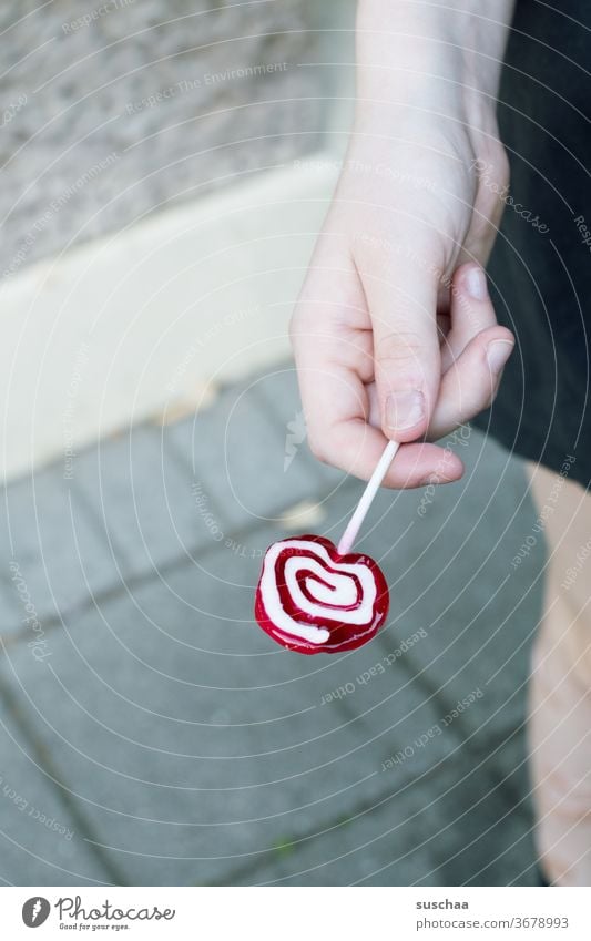 hand, die einen lolly hält Lolly Dauerlutscher Hand Jugendliche Teenager Kind lutschen Süßigkeit Zucker Kindheit süß Xylit zahnfreundlich Zahnarzt Süßwaren