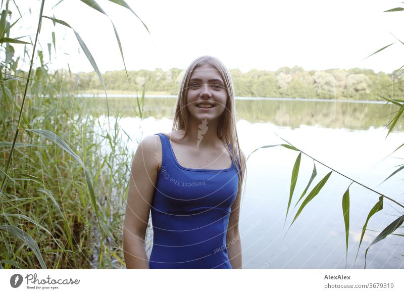 Portrait einer jungen Frau in blauem Sommerkleid in einem See am Ufer Reinheit Glück Schönes Wetter Ausflug Erwartung Sonnenlicht Nahaufnahme Tag