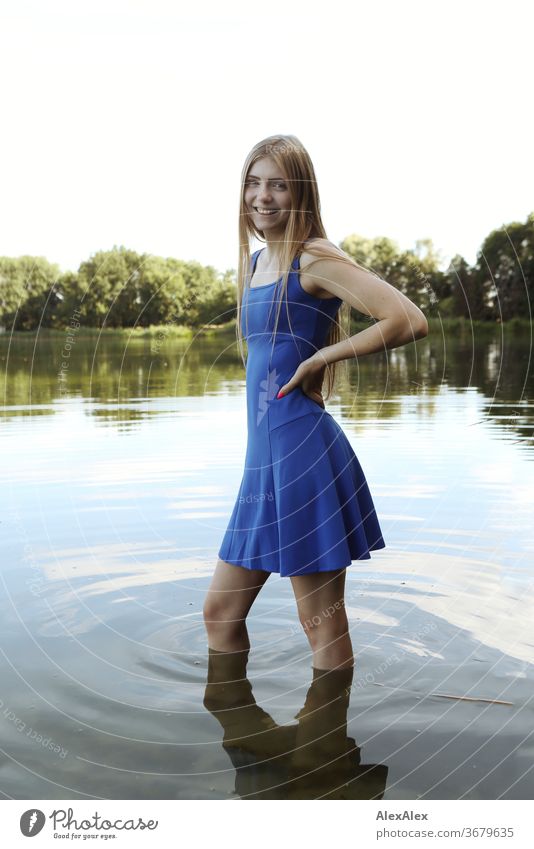 Portrait einer jungen Frau in blauem Sommerkleid in einem flachen See am Ufer Reinheit Glück Schönes Wetter Ausflug Erwartung Sonnenlicht Nahaufnahme Tag