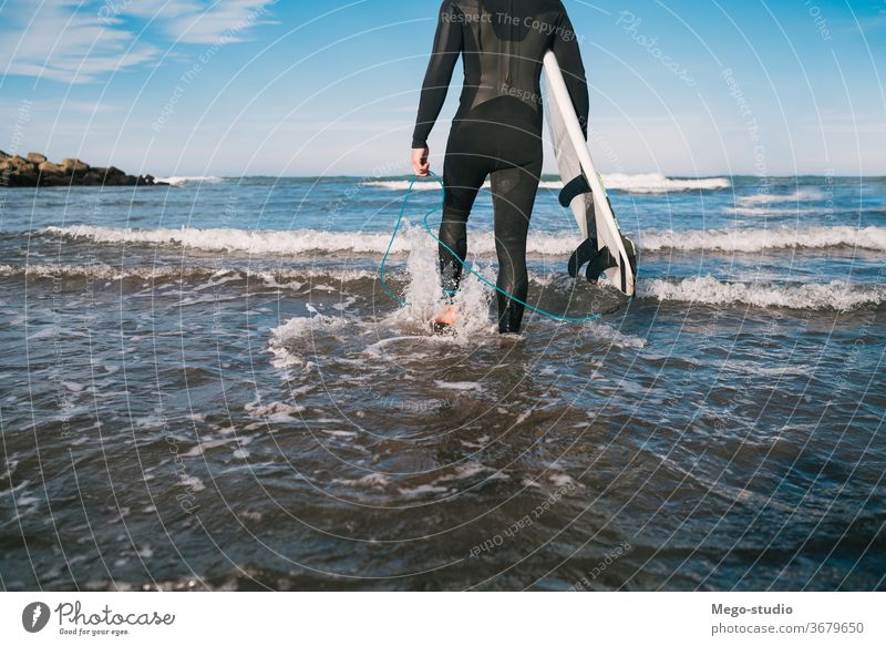 Surfer, der mit seinem Surfbrett ins Wasser geht. Mann Brandung Sport Surfen MEER Meer im Freien sportlich malerisch Küstenlinie Wellen Hintergrund Abenteuer