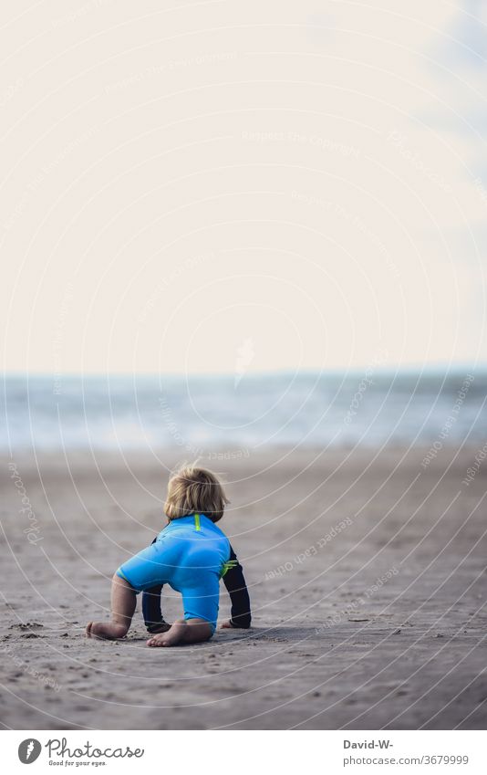 kleiner Junge fühlt sich vom Meer magisch angezogen Kind Kleinkind betrachten betrachtend beeindruckt Ozean Wellen Urlaub Strand alleine schauen denken Gedanken