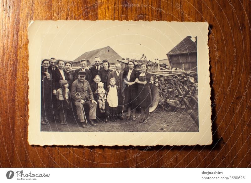 Familien Foto auf dem Lande. Alle stehen  um den Großvater , und Großmutter herum. Im Hintergrund ein Holzstoß . Ganz alte Aufnahme der Familie auf dem Land. Ostpreußische Impressionen
