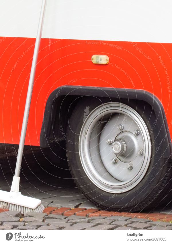 Weißer Schrubber der an der Rückseite eines roten Verkaufswagen lehnt Fahrzeug Reifen Rad Detailaufnahme Außenaufnahme Verkehr PKW Lastwagen Anhänger Farbfoto