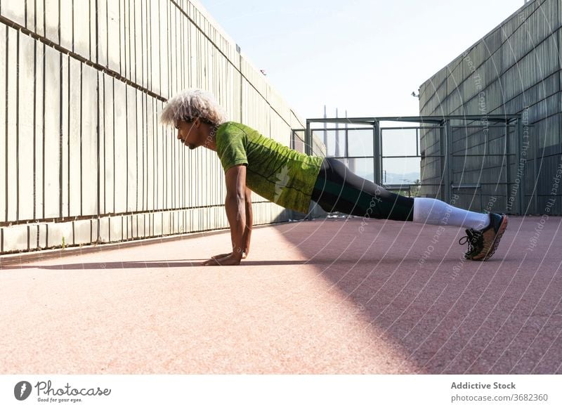 Afroamerikanischer Sportler macht Liegestütze auf der Straße Großstadt Fitness Training hochschieben Gehege Übung passen physisch männlich Wellness stark