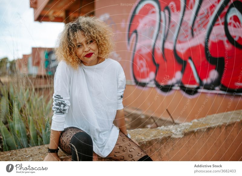 Provokante weibliche Millennials auf der Straße tausendjährig provokant Frau Graffiti Großstadt urban trendy emotionslos kreativ Frisur ethnisch schwarz