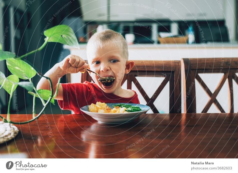 Süßes Kind, Vorschulkind, isst Gemüse zum Mittagessen im Speisesaal Kindheit Lebensmittel Glück Löffel veggies Mund Salatgurke Kartoffel hungrig Freude