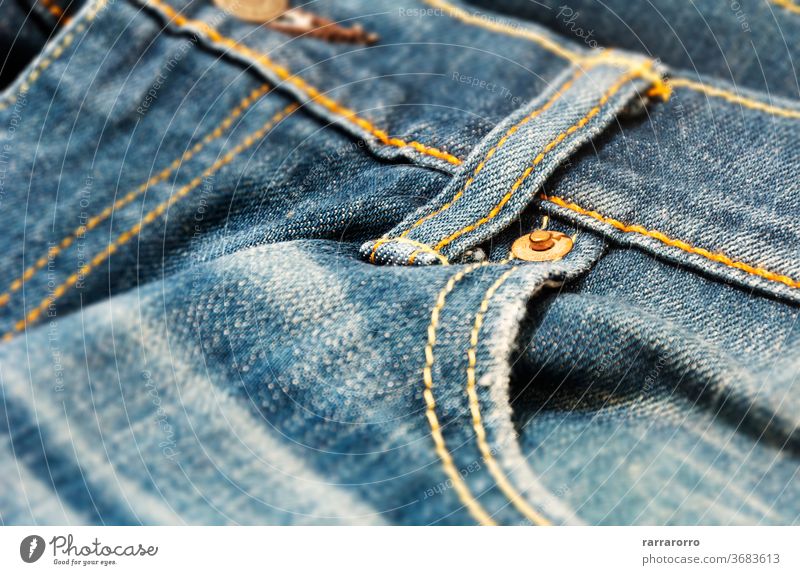 Nahaufnahme der Kupferniete auf der Tasche einer Jeanshose Niete Jeansstoff kupfer Leinwand Gewebe Textur blau Mode Bekleidung Kleidung Design Muster Material