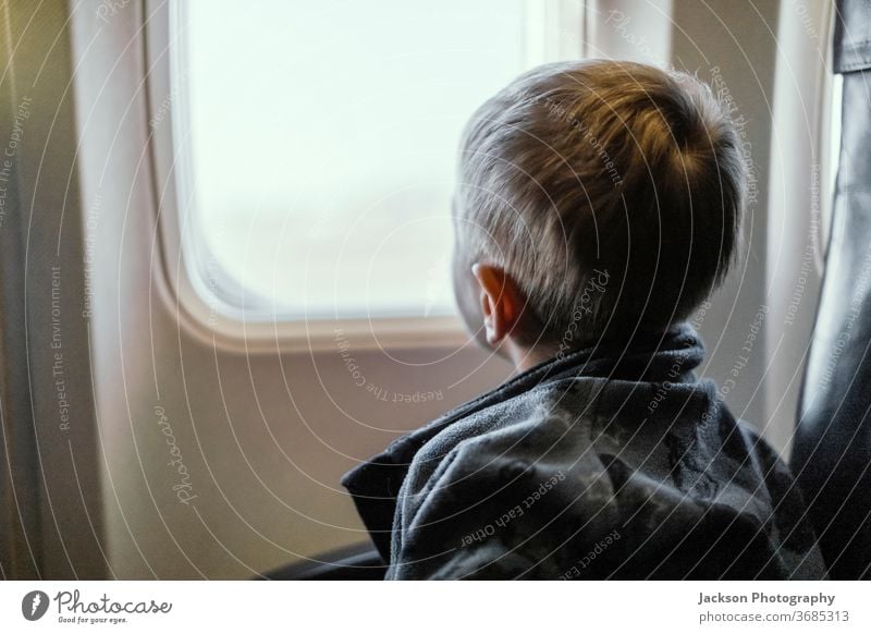 Kleinkind schaut durch ein Flugzeugfenster Junge reisen Fenster Aussehen durchblickend neugierig klein Kaukasier Gesicht Ansicht im Innenbereich Konzept