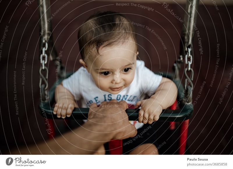 Vater hält Baby auf der Schaukel pendeln Spielplatz Zusammensein Zusammengehörigkeitsgefühl Vaterschaft Säuglingsalter Sichtweise Lifestyle Familie Menschen