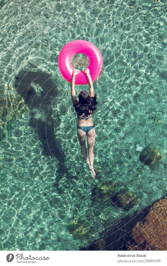 Frau schwimmt im Wasser mit Ring schwimmen Urlaub Resort Sommer Badebekleidung durchsichtig aufblasbar Tube sonnig tagsüber sich[Akk] entspannen Erholung ruhen