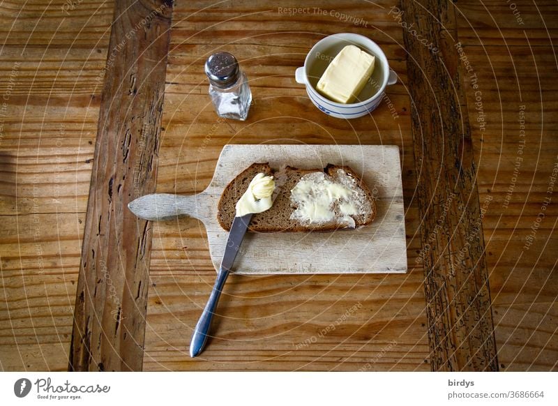 Brotzeit, Brot , Butter und Salz mit Vesperbrett auf einem Holztisch. Butterbrot vesperbrett rustikal Bäuerlich Messer Graubrot zünftig einfach lecker Essen
