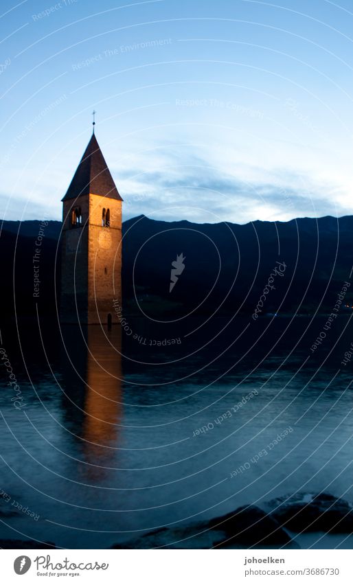 Kirche im Reschensee Kirchturm Kirchturmspitze See abgesoffen unter Wasser Überschwemmung Turmuhr Hochwasser Abendstimmung spiegeln Abenddämmerung Untergang