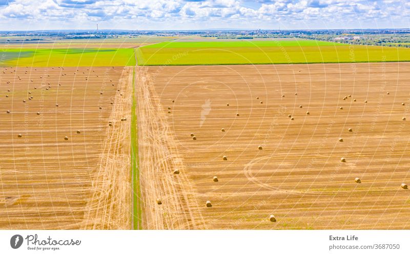 Luftaufnahme einer schmutzigen Straße zwischen landwirtschaftlichen Feldern oben quer Antenne Ackerbau unter Unter Ballen Borte Müsli einlochen Landschaft Ernte