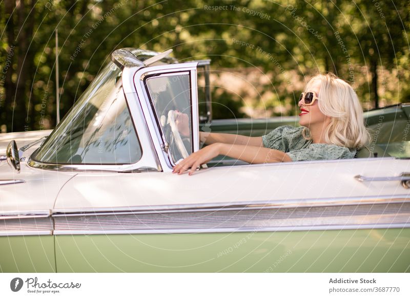 Glückliche Frau fährt Retro-Auto Fahrer PKW retro Sommer Lächeln sonnig tagsüber blond Stil positiv Sonnenbrille altehrwürdig Fahrzeug Verkehr Freude Reise