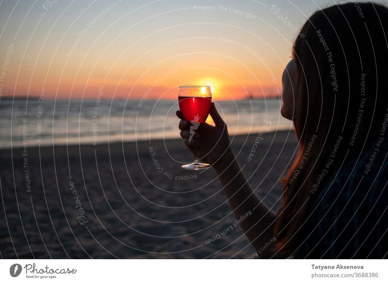 Frau mit einem Glas Wein am Strand bei Sonnenuntergang trinken Alkohol romantisch genießend langsames Leben sich[Akk] entspannen MEER schön Feier Getränk
