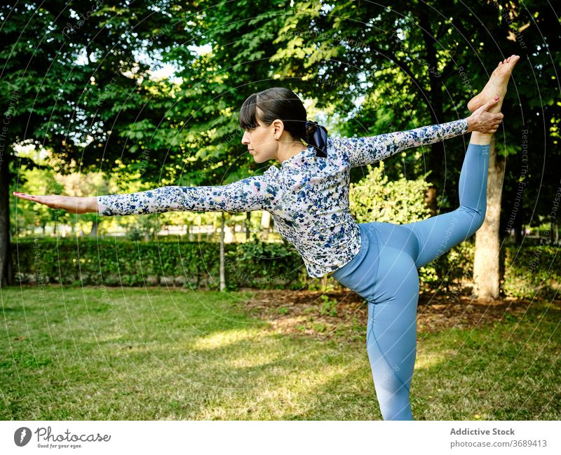 Frau macht Yoga in Lord of the Dance Pose im Park Herr des Tanzes beweglich Asana Natarajasana Konzentration Windstille Natur Gesundheit üben sonnig Harmonie