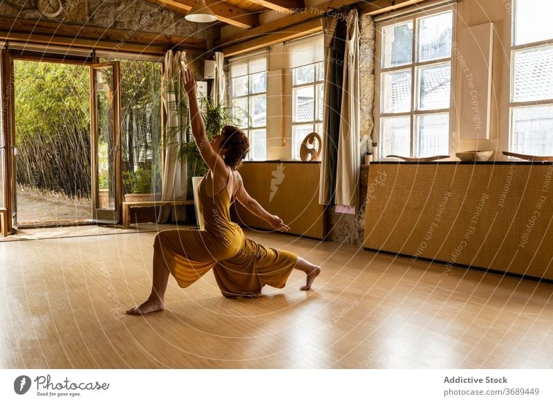 Serene Frau übt Yoga in Crescent Lunge Position anjaneyasana halbmondförmiger Ausfallschritt Pose üben beweglich Gelassenheit Harmonie Achtsamkeit Atelier