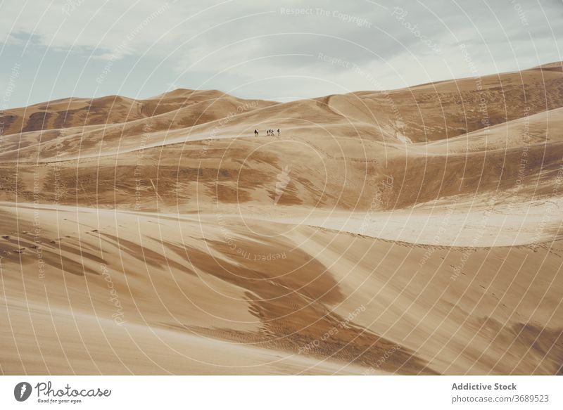Reisende auf sandigen Dünen an einem bewölkten Tag Sand Tourist Menschengruppe national Park wüst Wahrzeichen Tourismus Colorado USA Vereinigte Staaten amerika