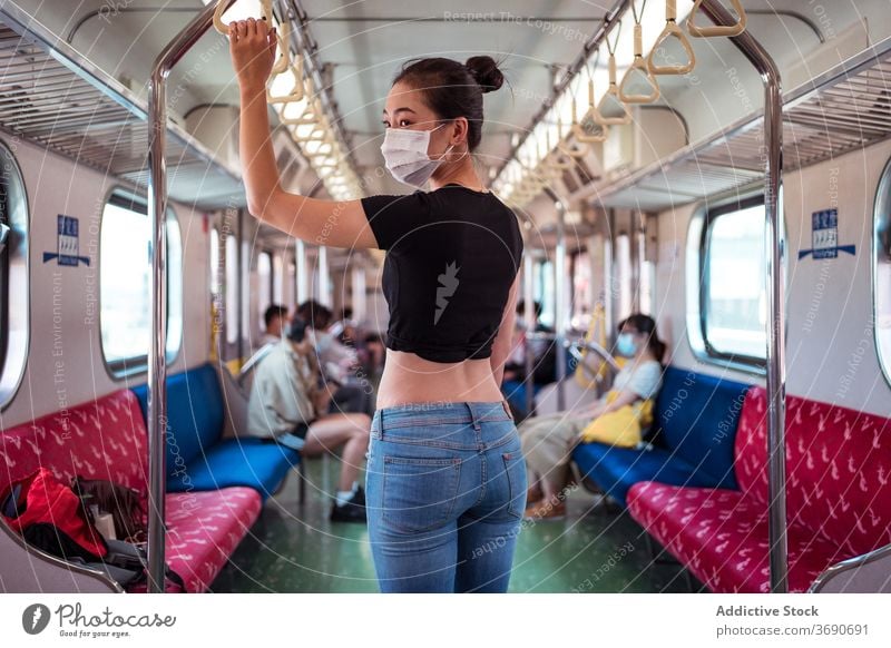 Asiatische Frau in Maske im Zug reisen Mundschutz Coronavirus Öffentlich Verkehr Ausbruch behüten Arbeitsweg ethnisch asiatisch modern Passagier stehen Ausflug