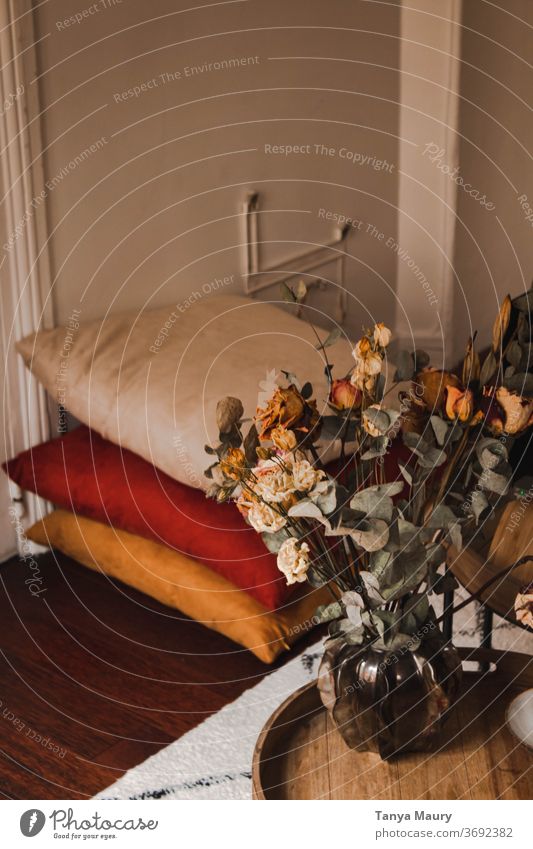 Gemütliches Wohnzimmer mit bunten Kissen und einer Vase voller Trockenblumen auf einem Holztisch Herbst Herbststimmung Atmosphäre November nordisch Hygge bequem