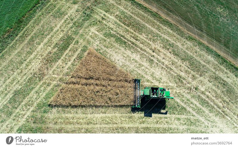 Dreieck Ernte Feld Landwirtschaft Mähdrescher Feldarbeit Traktor mähen dreschen oben Luftaufnahme grün trocken Ackerbau Erntezeit Spuren geometrisch Geometrie