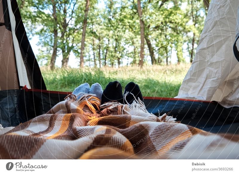 Zwei Personen liegen in einem Touristenzelt, Innenansicht. Füße unter den Decken im Zelt. Touristisches Lager im Inneren Wald Hintergrund Tourismus Natur wild