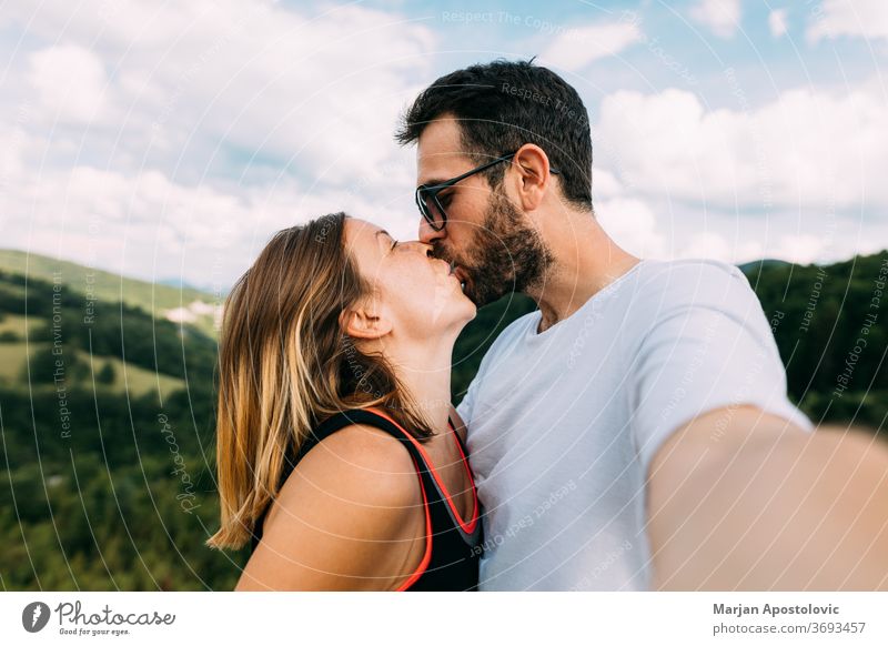 Junges Paar beim Küssen in den Bergen beim Selfie Erwachsener Abenteuer anhänglich schön Freund Fotokamera lässig Kaukasier heiter emotional erkunden Freundin