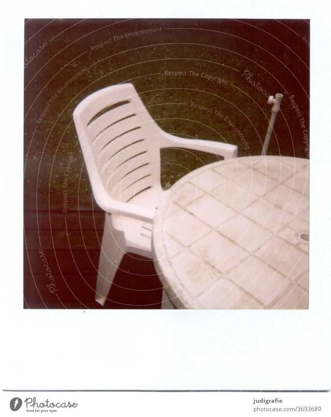 Weißer Gartenstuhl mit Tisch auf Polaroid Möbel Stuhl Plastikstuhl Gartenmöbel Menschenleer Sitzgelegenheit Außenaufnahme Farbfoto Terrasse Sommer Pause alt