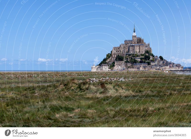 Strohrollen auf einem Feld, im Hintergrund Mont St. Michel Frankreich Bretagne Sommer Sonne Getreideernte blauer Himmel grün schöner Tag Urlaub Reise Ferien