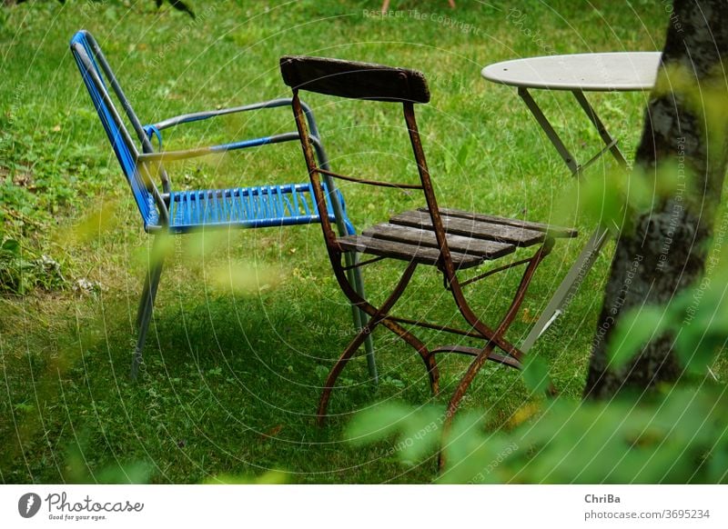 Sitzecke im Garten mit alten, zusammengewürfelten Gartenmöbeln Sitzgelegenheit Tisch Stuhl vintage gemütlich hygge wabisabi Kaffeetisch Gartenstuhl Sommer