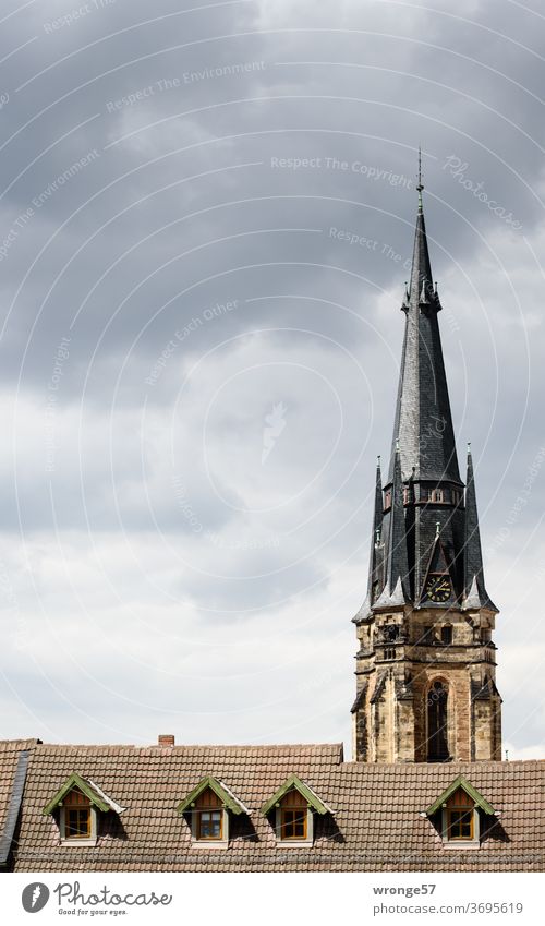 Gegensätze | in der Bauhöhe Gebäudehöhe Kirchturm Wernigerode Hausdach Gauben Kirchturmspitze Himmel Wolkenhimmel bewölkt Kirche Außenaufnahme Farbfoto