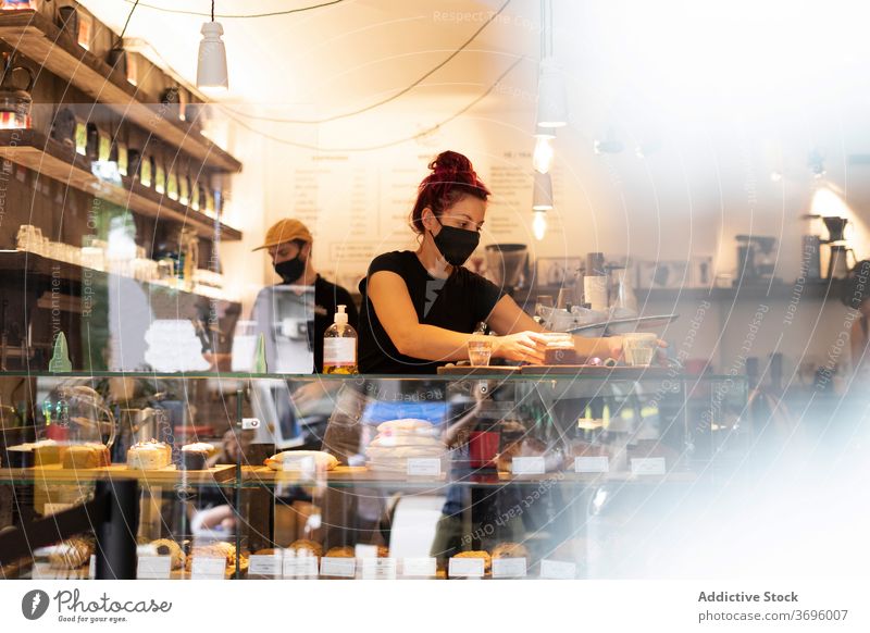 Kellner und Kellnerin arbeiten im Café Barista vorbereiten Kaffee Zusammensein Mitarbeiterin Abfertigungsschalter Coronavirus Mundschutz Kaffeehaus neue Normale
