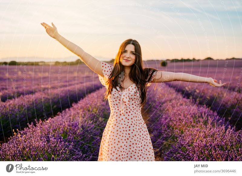Glückliche Frau in einem Kleid und mit offenen Armen im Lavendelfeld. offene Arme schön Fröhlichkeit Feld Freiheit Lächeln jung Natur purpur Frühling Model