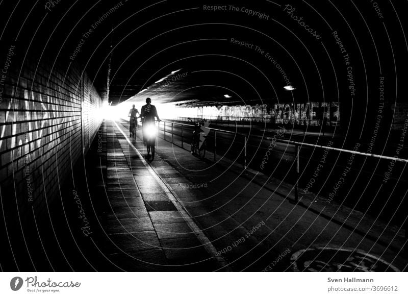 Radfahrer im Tunnel Verkehr Großstadt Geschwindigkeit Außenaufnahme fahren Ausflug Schattenspiel Straße urban Lifestyle Transport Fahrradfahren Bewegung Kunst