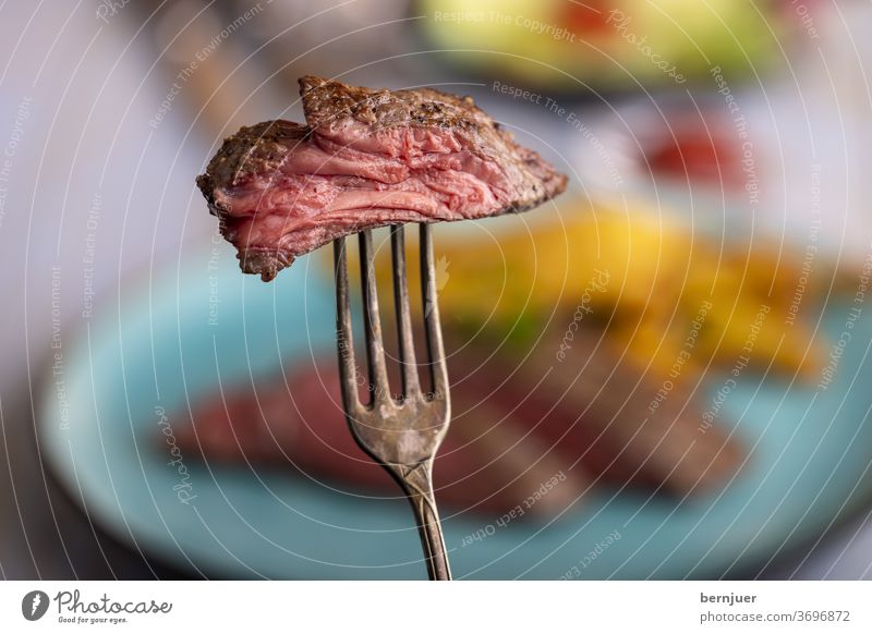 Scheibe Steak auf einer Gabel Rindfleisch Rindersteak medium aufgespießt Stück Sirloin Braten geröstet Fleisch saftig geschnitten Silbergabel rot Essen roh