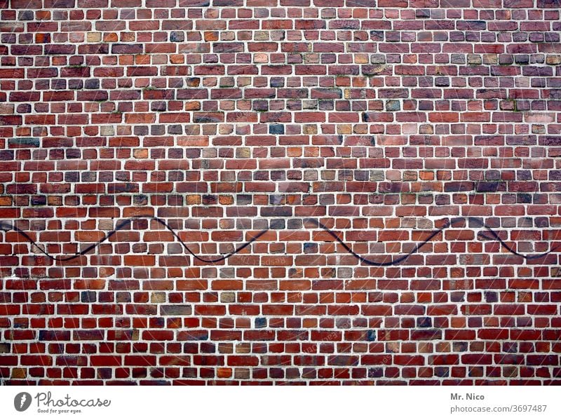 Wellenlinie auf einer Backsteinmauer Wand Mauer Backsteinwand Haus Mauerwerk Ziegelwand Altbau Fassade Strukturen & Formen Ziegelsteine rot gebäude gemauert