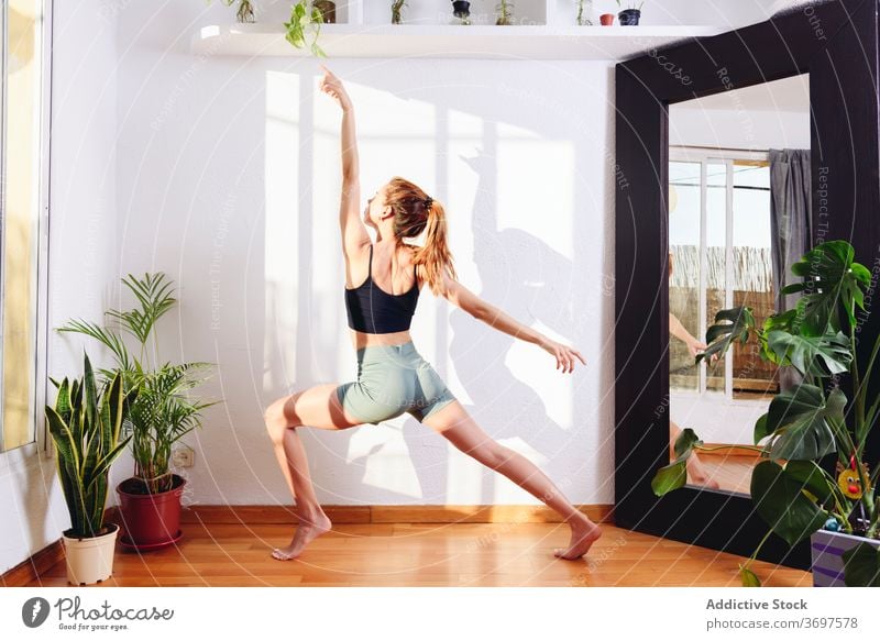 Flexible Frau übt Yoga in Krieger zwei Pose beweglich Stressabbau Asana virabhadrasana üben positionieren Windstille Zen Wellness meditieren Harmonie heimwärts