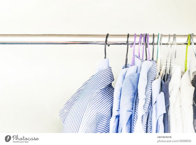 Eine Gruppe von Herrenhemden in verschiedenen Farben, die mit Kleiderbügeln in einem Schrank aufgehängt sind Hemd erhängen Kleiderschrank Baumwolle Gewebe