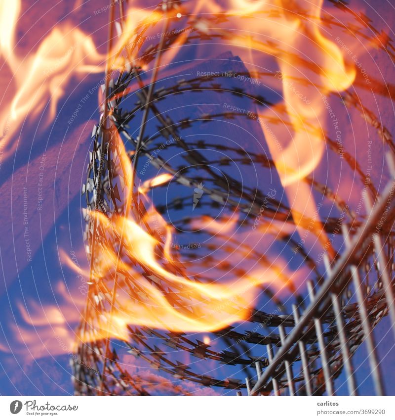 Heißes Eisen - nicht anpacken Zaun Stacheldraht Feuer brennen Absperrung einsperren Gefängnis Lager Verbot Brand Flamme Wärme gelb rot blau Gefahr Sicherheit