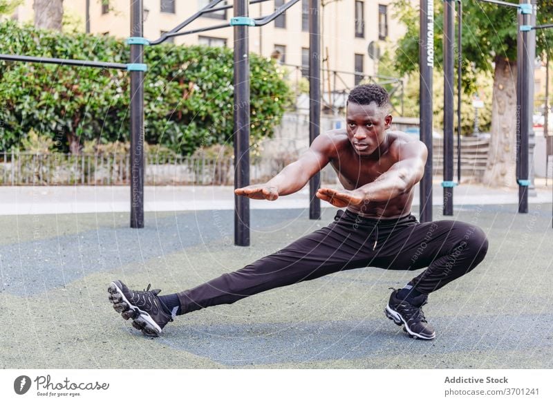 Starker Sportler macht Ausfallschritte auf der Straße Mann Übung Training sportlich Athlet stark ohne Hemd muskulös Sportpark männlich Afroamerikaner schwarz