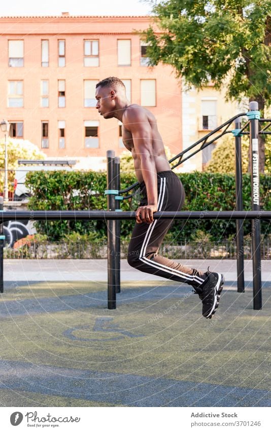 Muskulöser schwarzer Sportler macht Klimmzüge hochziehen Training stark Übung Athlet Ausdauer nackter Torso männlich ethnisch Afroamerikaner intensiv Fitness