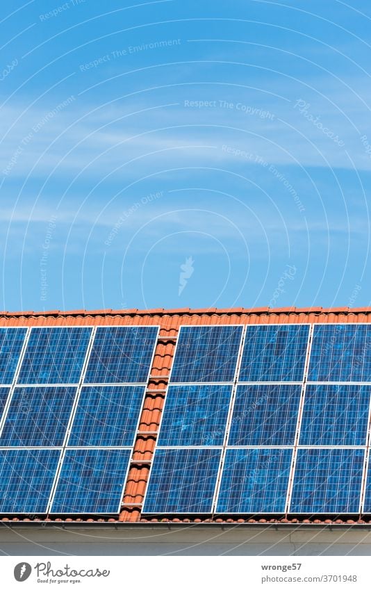 Nahaufnahme einer Solaranlage auf einem roten Ziegeldach unter blauem Himmel Sonnenenergie Solarenergie Photovoltaikanlagen Solarzellen Elektrizität Farbfoto