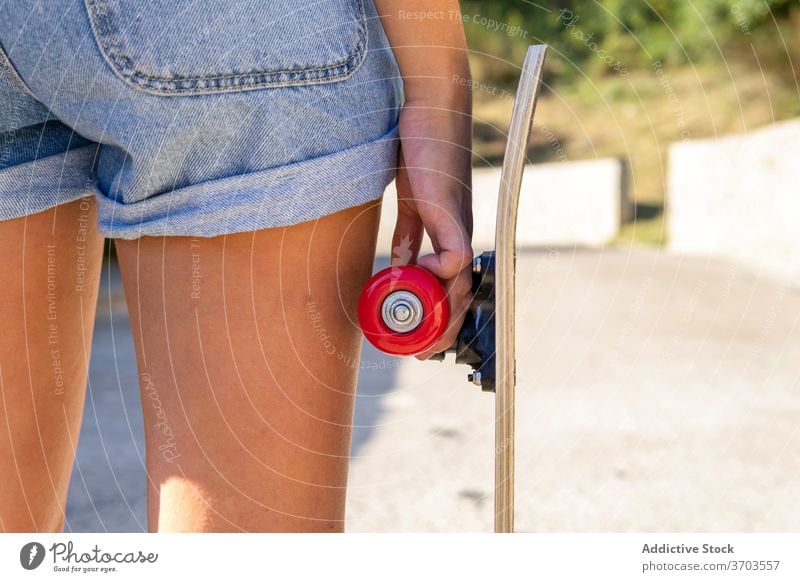 Junge Frau mit Skateboard auf der Straße stehend tausendjährig Schlittschuh Sommer Großstadt sonnig jung sich[Akk] entspannen trendy tagsüber modern Stil
