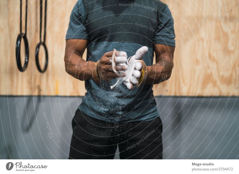 Fitness-Mann, der sich die Hände mit Kreide-Magnesium-Pulver einreibt. Fitnessstudio Training Sport jung Nahaufnahme Gesundheit Aktivität Magnesia Hand Porträt