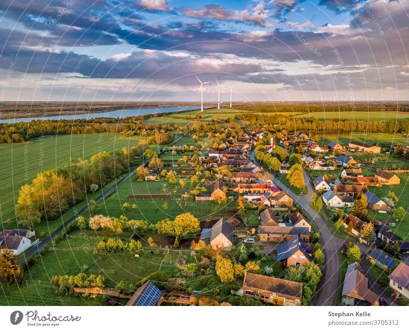 Luftaufnahme über einer kleinen Stadt mit Windrädern und einem See im Hintergrund einer deutschen Landschaft. Windrad Dorf Wolken Laufwerk hoch Natur